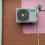 Airco buitenunit gemonteerd aan bakstenen gevel