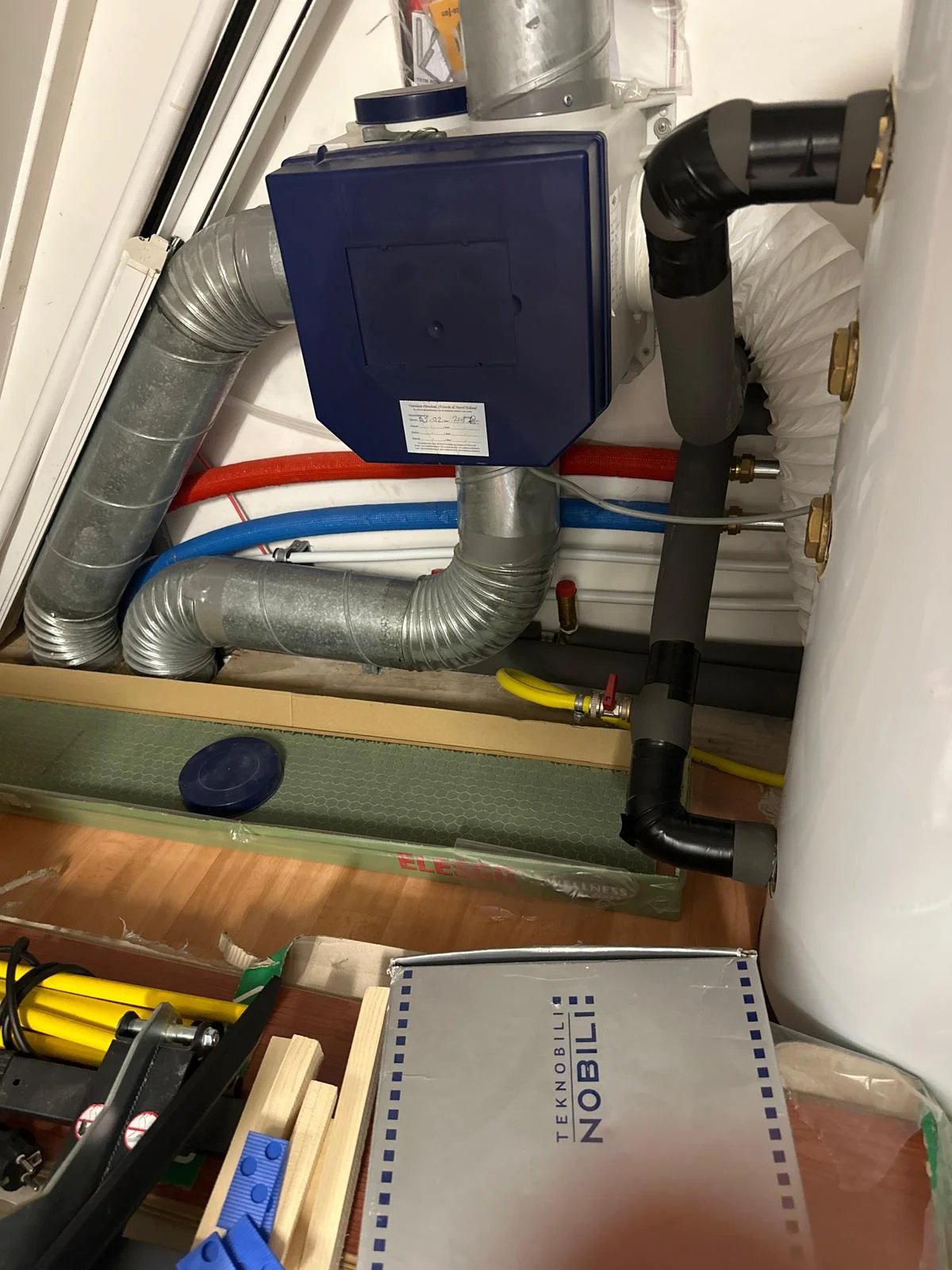 WTW-ventilatie-unit met luchtkanalen en geïsoleerde leidingen