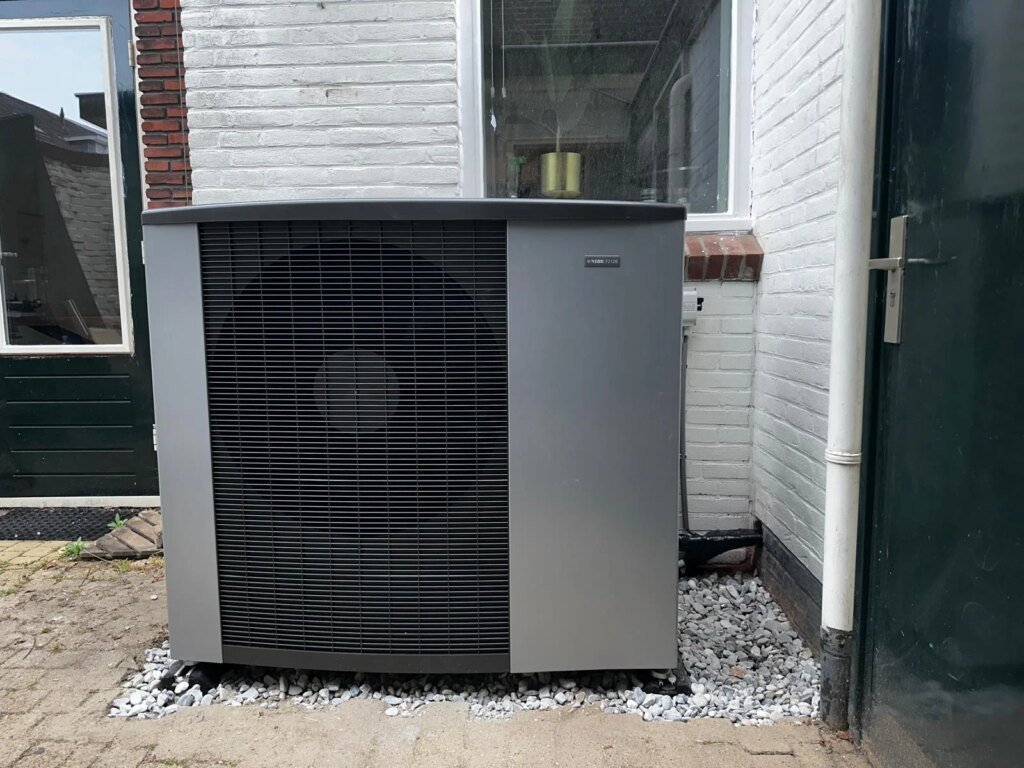 Lucht-water warmtepomp buitenunit geplaatst naast woning