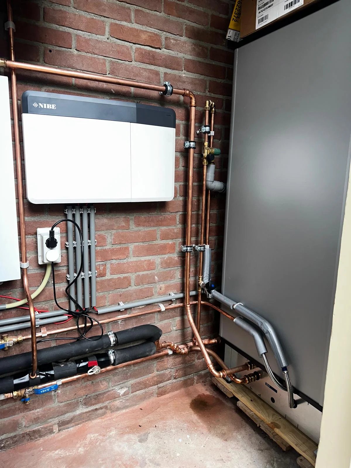 NIBE warmtepomp binnenunit met buffervat en leidingwerk