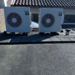 Twee Mitsubishi airco buitenunits op dak geplaatst