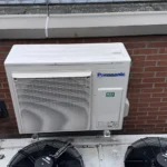 Airco onderhoud Amsterdam met Panasonic airco buitenunit gemonteerd tegen gevel