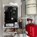 Cv ketel met expansievat en leidingwerk in kast