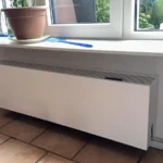 Lage convector radiator onder vensterbank geplaatst