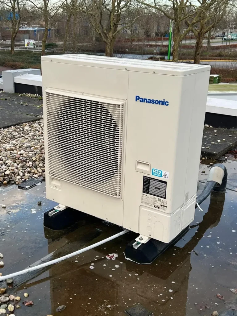 Airco onderhoud Amsterdam met Panasonic buitenunit van warmtepomp op plat dak